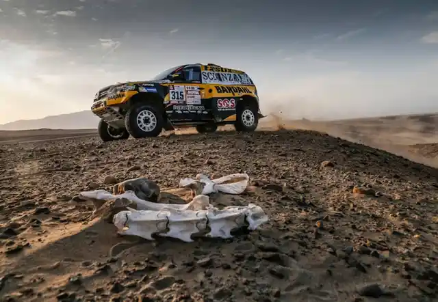 A Renault car passes through the mighty terrain.