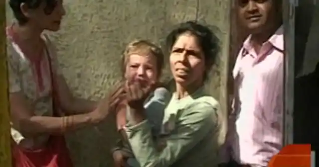 Sandra Samuel exiting the Chabad House with Moshe in her arms