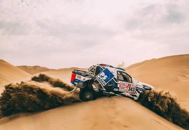 A Toyota rookie driver struggles to get his off-roader out of the fine sand.
