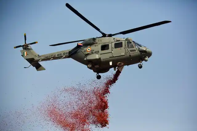 An Indian Air Force helicopter sprays flower petals during Republic Day parade in Gauhati, India, Friday, 26 January 2018.