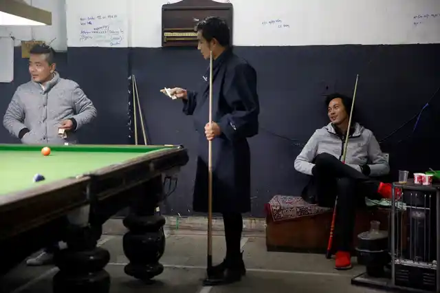 Men play snooker and gamble in a snooker hall in the capital city of Thimphu, Bhutan, 12 December 2017. 