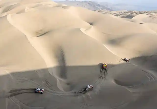Off-roaders battle it out among the deep sand in Peruvian desert.