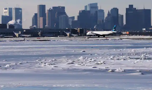 Ahead of an incoming winter snow storm, a Jet Blue flight waits to take off from Logan International Airport next to the frozen waters of the Atlantic Ocean harbour between Winthrop and Boston, Massachusetts, US.