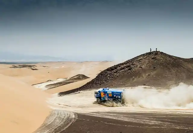 A truck speeds across the desert.