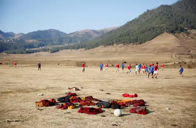 Buddhist monks play football in the Phobjikha Valley, Bhutan, 14 December 2017. 