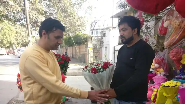 Gangadhar Singh showing a bouquet to one of his customers