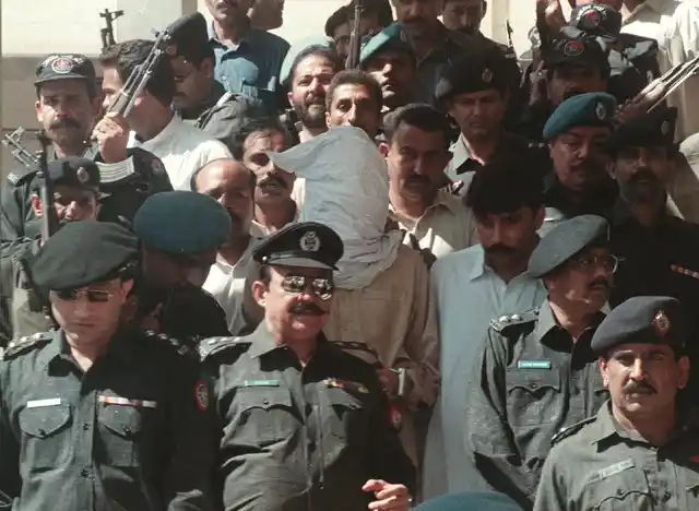 A heavily guarded Omar on his way to a hearing. 