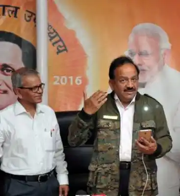 The minister demonstrates Solar Jacket by charging a phone.