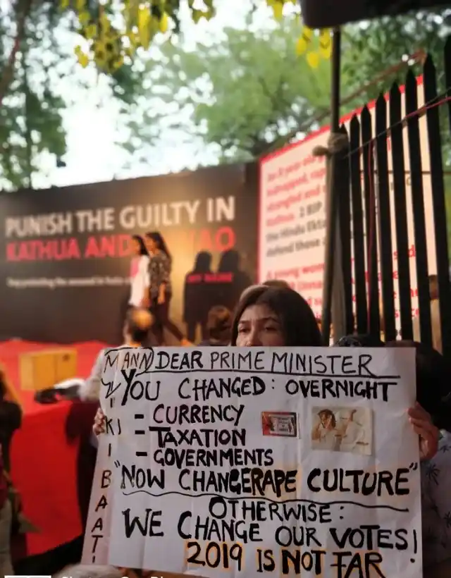 A woman holding a placard asking the PM to take action and change the “rape culture.”