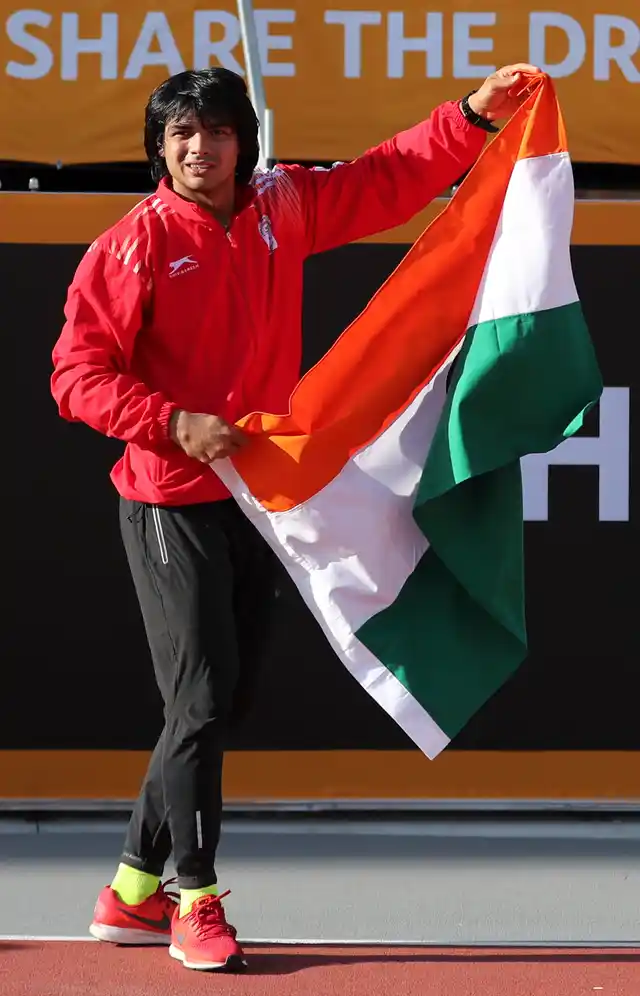 India’s Neeraj Chopra holds the national flag after winning gold in the men’s javelin final at Carrara Stadium during the Commonwealth Games.