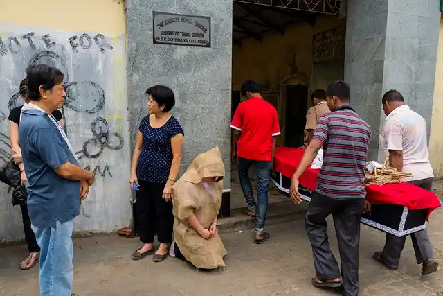 A lady, dressed in clothes made of gunny sack, pays a traditional Hakka Chinese tribute to her father whose coffin is being carried to the cemetery for burial. She had come to attend the funeral ceremony in Kolkata from Canada.