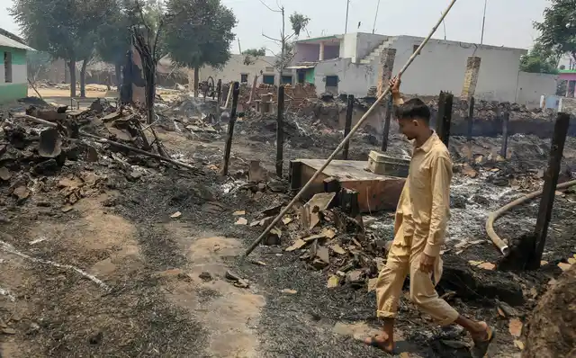 A villager walks past a damaged house after heavy shelling allegedly fired by Pakistani forces, at border village Jora Farm in R S Pura Sector, Jammu, on Tuesday.