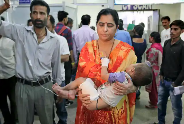 A woman carries her son injured in cross-border firing to a hospital, in Jammu on Wednesday.