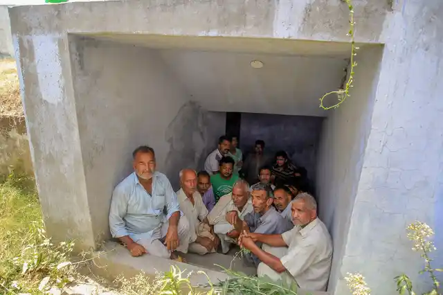 Villagers take shelter under a community bunker during alleged shelling.