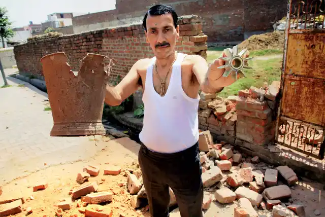 A villager shows parts of mortar shell. 