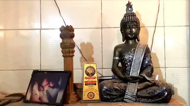The picture of Haribabu’s youngest son on a table along the Buddha idol. In the middle is an award given to his granddaughter by the Buddhist Society of India for performing well in her studies.