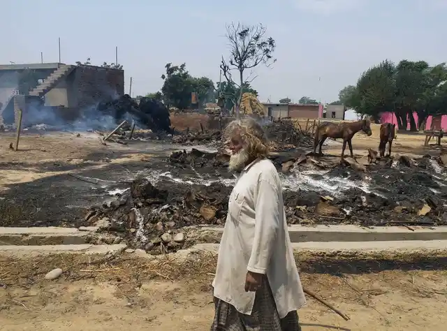 An Indian man inspects the damage after his house was gutted by firing allegedly from the Pakistan side of the border.