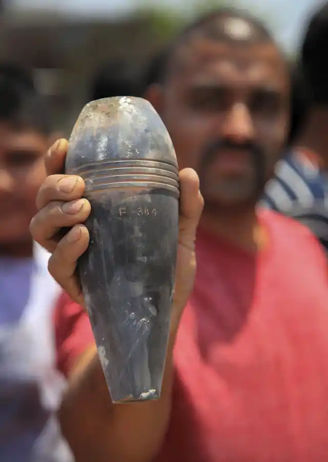 A vilager shows a shell, allegedly fired from the Pakistani side.