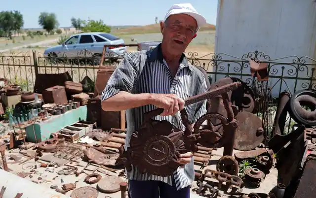 72 year old Vitaly Danilkin holds up memorabilia and remains of battles that took place near Stalingrad, in Rossoshka, Russia. 