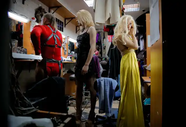 Andrei, who uses the stage name Star Vasha, right, Dmitry, who performs under the stage name Africa, center, and Sergey, or artistic name Bomba (The Bomb), prepare before performing at a Gay club during the 2018 soccer World Cup in Yekaterinburg, Russia.