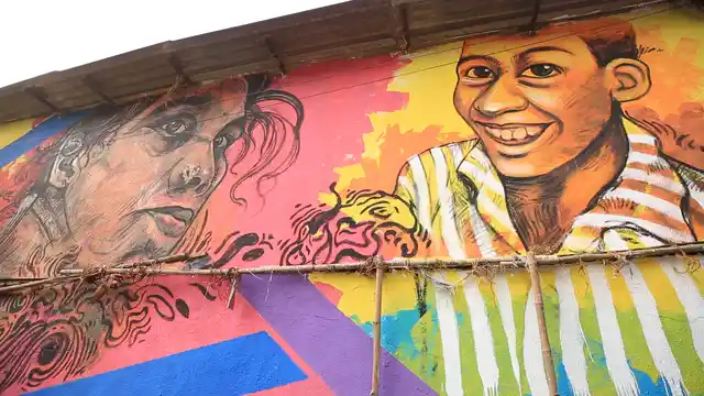 Painting of a vegetable vendor and her son on a wall in Khar Danda 