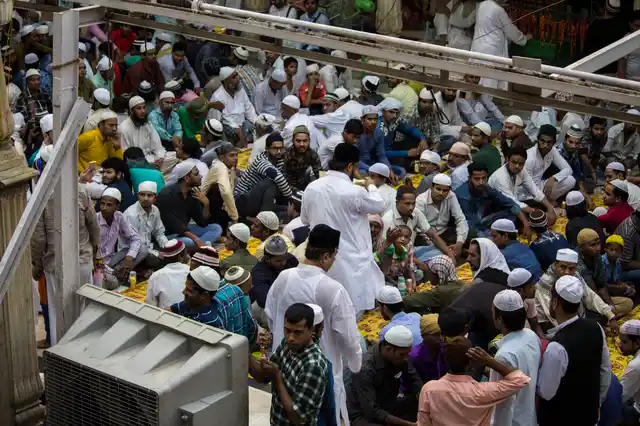 People sit in the courtyard around the shrine. 