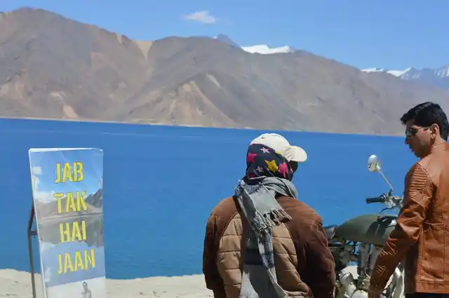 Two tourists near a poster of the movie ‘Jab Tak Hai Jaan’.