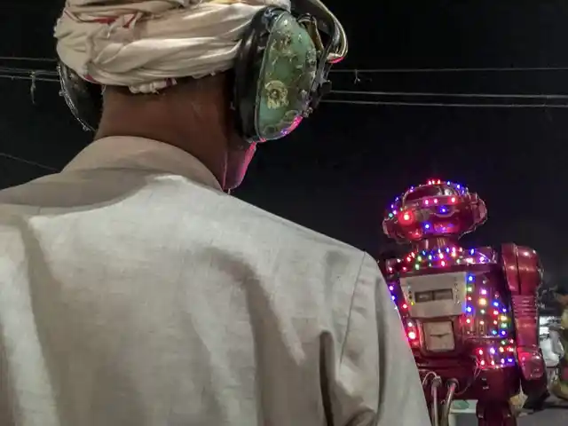 Man listening to what a robot has to predict for his future, a common sight at Indian fairs and festivals.