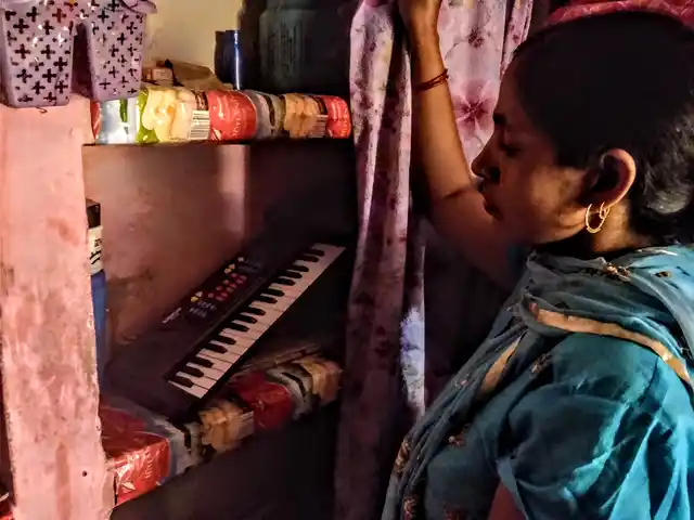 Abhishek’s mother showing his piano, which was kept behind curtains as there was no one to play with it in his absence.