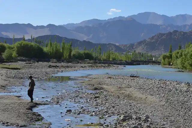 A boy crossing a small channel containing sewage which drains into the Indus near Choglamsar in Leh.