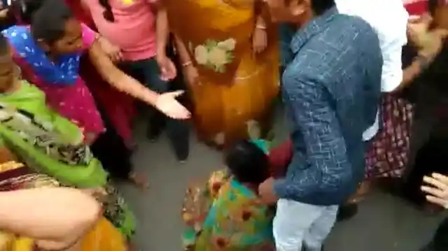Screenshot of a video where a mob is seen attacking a woman suspected to be a child kidnapper.