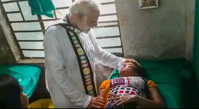 PM Modi meets a woman who was injured during his rally in Midnapore.