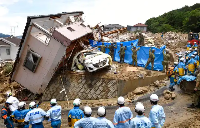 Rescuers conduct a search operation for missing persons in Kumano town, Hiroshima prefecture, western Japan, on Monday, 9 July.