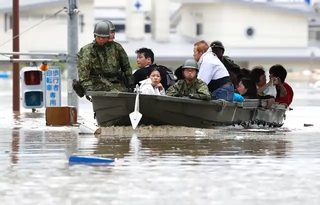 Japan’s Ground Self-Defence Force members use a boat to evacuate residents from a flooded area in Kurashiki.