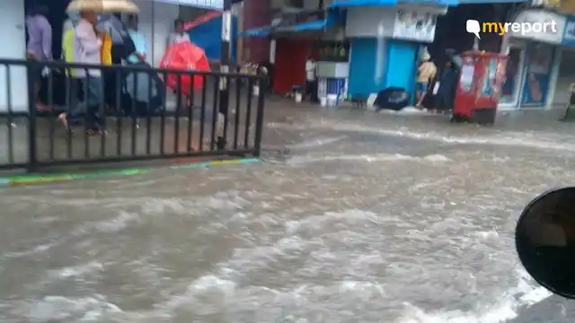 Commuters taking shelter from the heavy rains in Thane. 