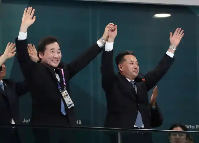 South Korean Prime Minister Lee Nak-yon (L), North Korean Vice Premier Ri Ryong Nam (R) join hands and wave during the opening ceremony.