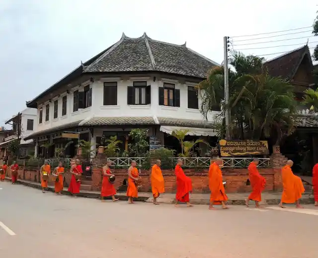 Locals shower the monks with rice, fruits and traditional sweets.