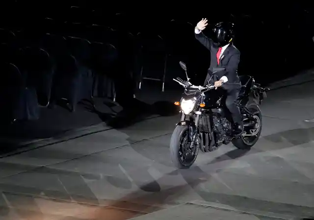President Joko Widido arrives on a motorbike to the venue of Gelora Bung Karno Stadium.