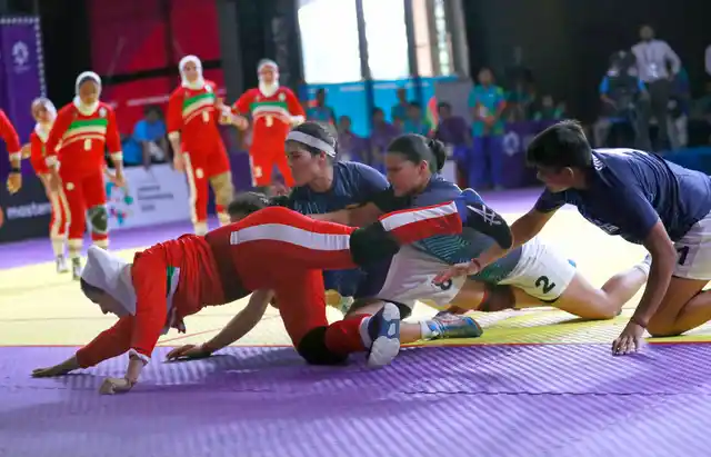 Iran’s Saeideh Jafarikoochi, in red, tries to stretch to the line.