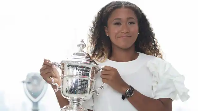 US Open women’s singles champion Naomi Osaka poses for photographers with her trophy at Top of the Rock Observation Deck at Rockefeller Center, Sunday, Sept. 9, 2018, in New York. 