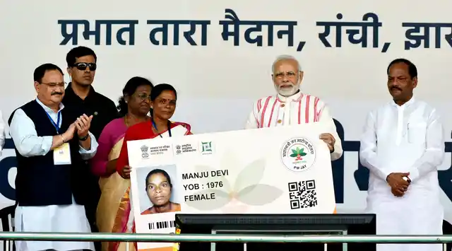 Prime Minister Narendra Modi presents a health insurance card to a beneficiary during the inauguration of “Pradhan Mantri Jan Aarogya Yojna” in Ranchi.