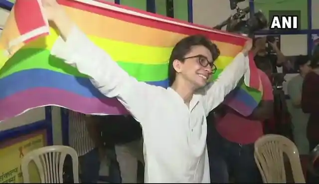 An activist in Delhi poses with the LGBTQ-flag.