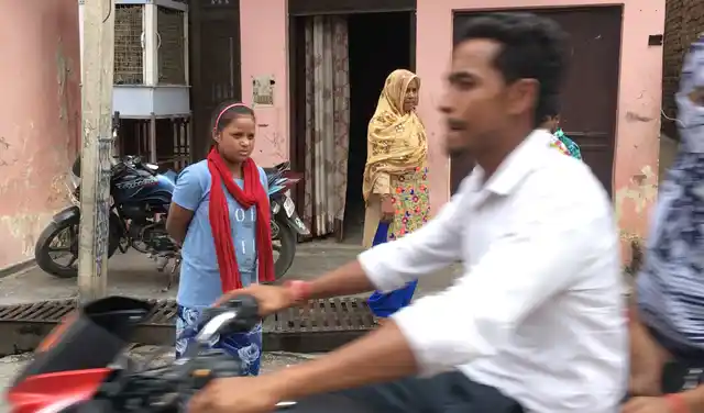 Raeesa Begum (head covered) outside her home in Rajapur village on the outskirts of Ghaziabad.