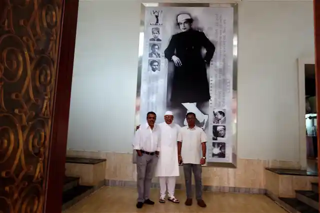 Kiran Shantaram (centre), flanked by his sons Rahul (left) and Chaitanya in front of Shantaram’s photograph.
