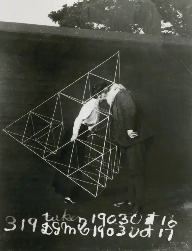 Alexander Graham Bell and Mabel kissing within a tetrahedral kite, October 1903.