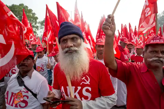 Farmers, workers and agricultural labourers wave red Communist flags as they arrive in the Indian capital for a two-day protest.