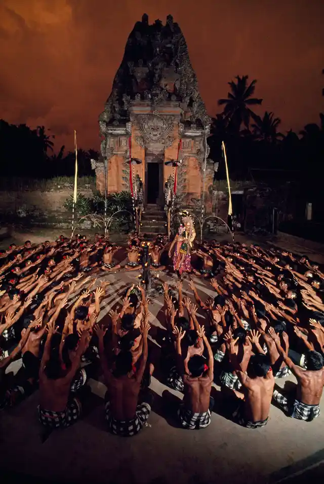 Seated villagers wave arms as they enact a play in front of a temple in Bali, Indonesia, 1969.