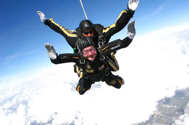 In this 2007 photo provided by the US Army Golden Knights, former President George HW Bush free falls with Golden Knights parachute team member Sgt 1st Class Mike Elliott, as he makes a dramatic entrance to his presidential museum during a rededication ceremony in College Station, Texas.