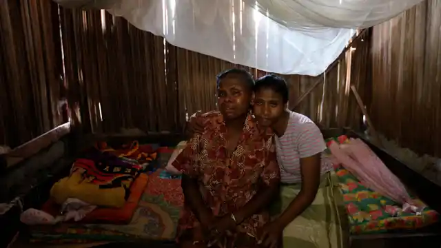 Yohanna Banunaek (left) is comforted by her daughter Yeti in Abi village of West Timor.