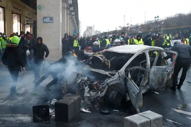 Officers fired tear gas and used water cannons to tamp down the violence as protesters torched cars, smashed windows, looted stores and tagged the Arc de Triomphe with spray paint.